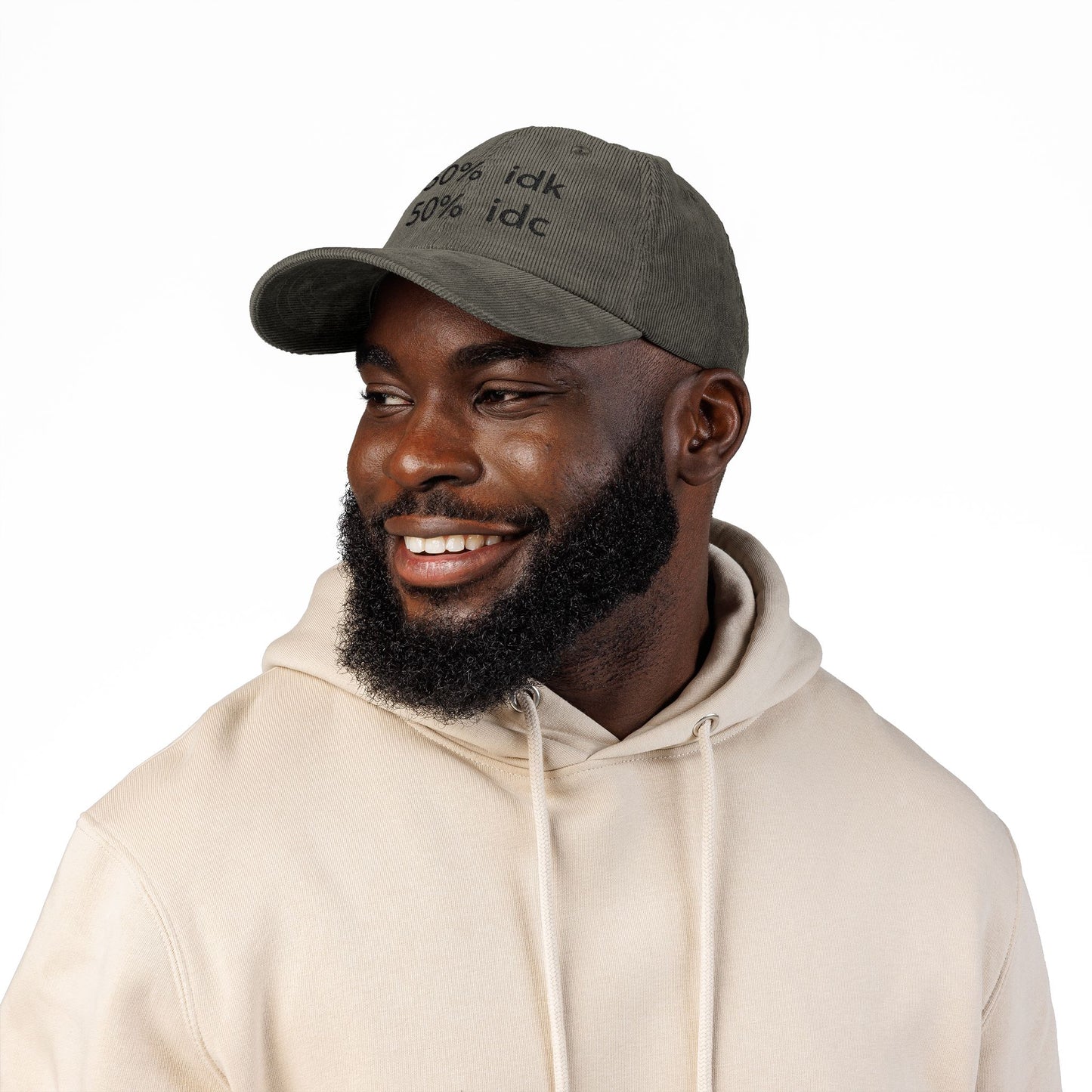 Man wearing a brown cap with a logo and a beige hoodie on a white background