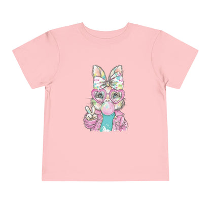 Pink t-shirt with a cartoon character wearing glasses and a bow on a white background