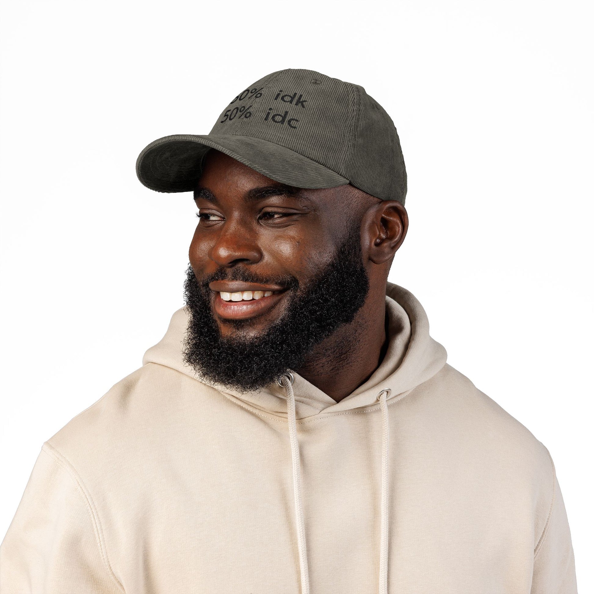 Man wearing a brown cap with a logo and a beige hoodie on a white background