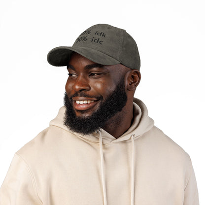 Man wearing a brown cap with a logo and a beige hoodie on a white background