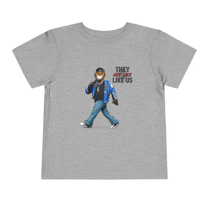 Gray t-shirt with a graphic of a person wearing a mask and text 'They Not Like Us' on a white background