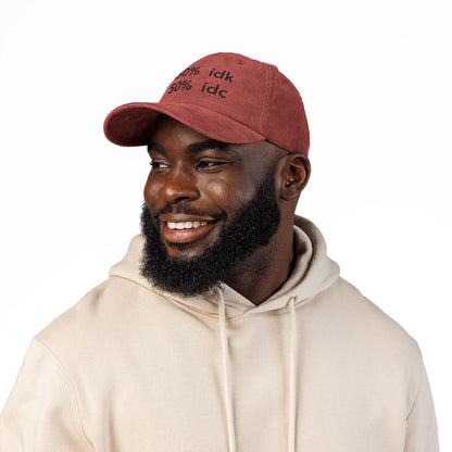 Man wearing a red cap with a logo and a beige hoodie on a white background