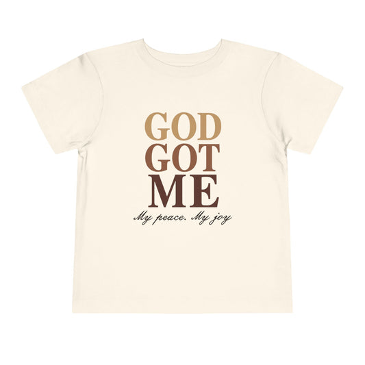 Beige t-shirt with 'God Got Me' text design on a white background