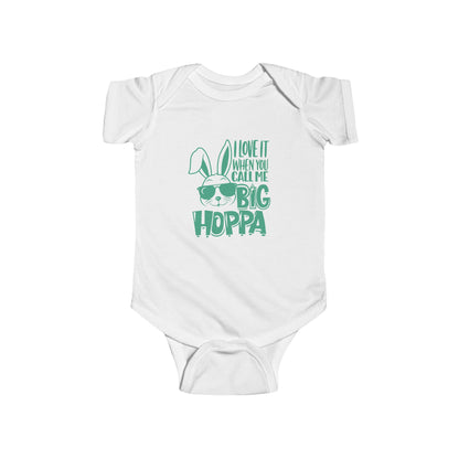 White baby onesie with green text and graphic on a white background