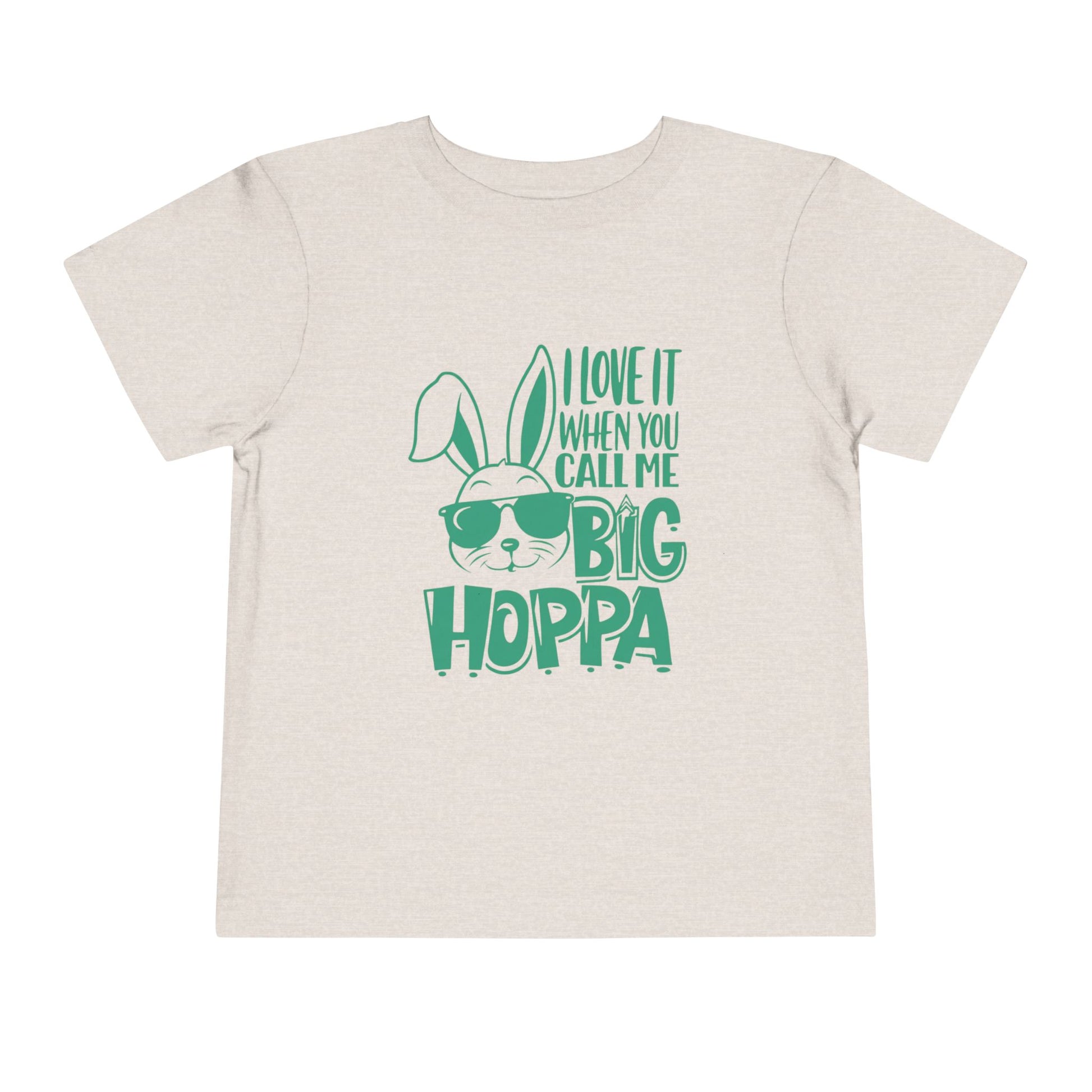 Beige t-shirt with green text and bunny graphic on a white background