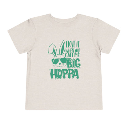 Beige t-shirt with green text and bunny graphic on a white background