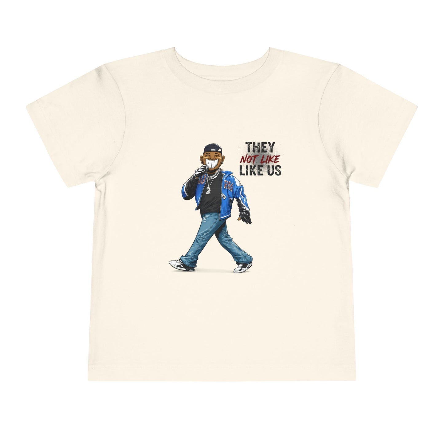 Beige t-shirt with graphic of a person wearing a mask and text 'They Not Like Us' on a white background