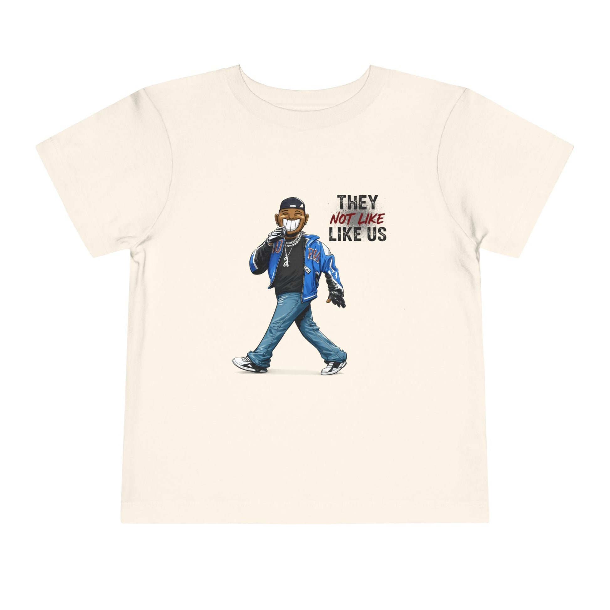 Beige t-shirt with graphic of a person wearing a mask and text 'They Not Like Us' on a white background