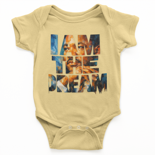Beige baby onesie with 'I AM THE DREAM' text on a white background