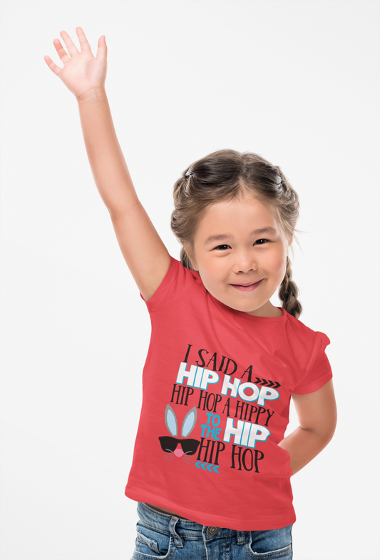 Child wearing a red t-shirt with text and graphics, raising one arm.
