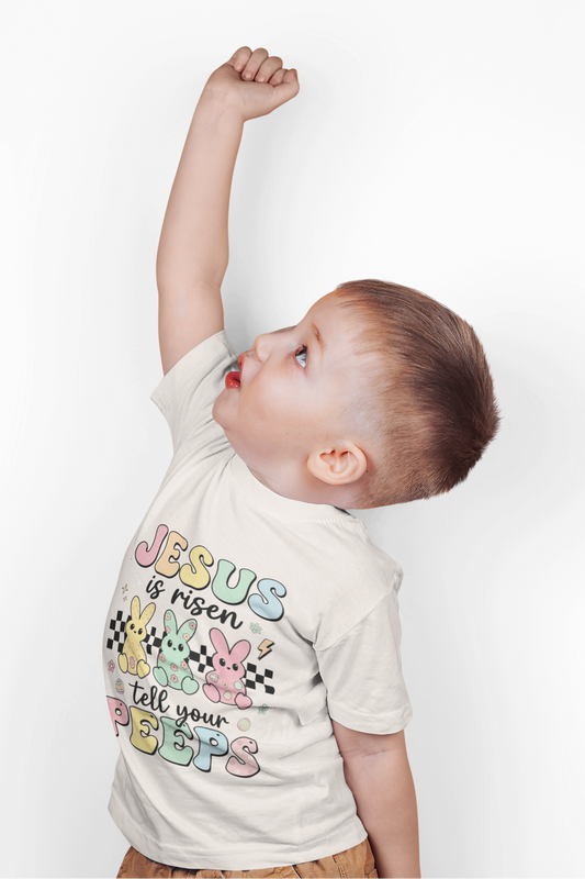 Child wearing a shirt with colorful text on a white background