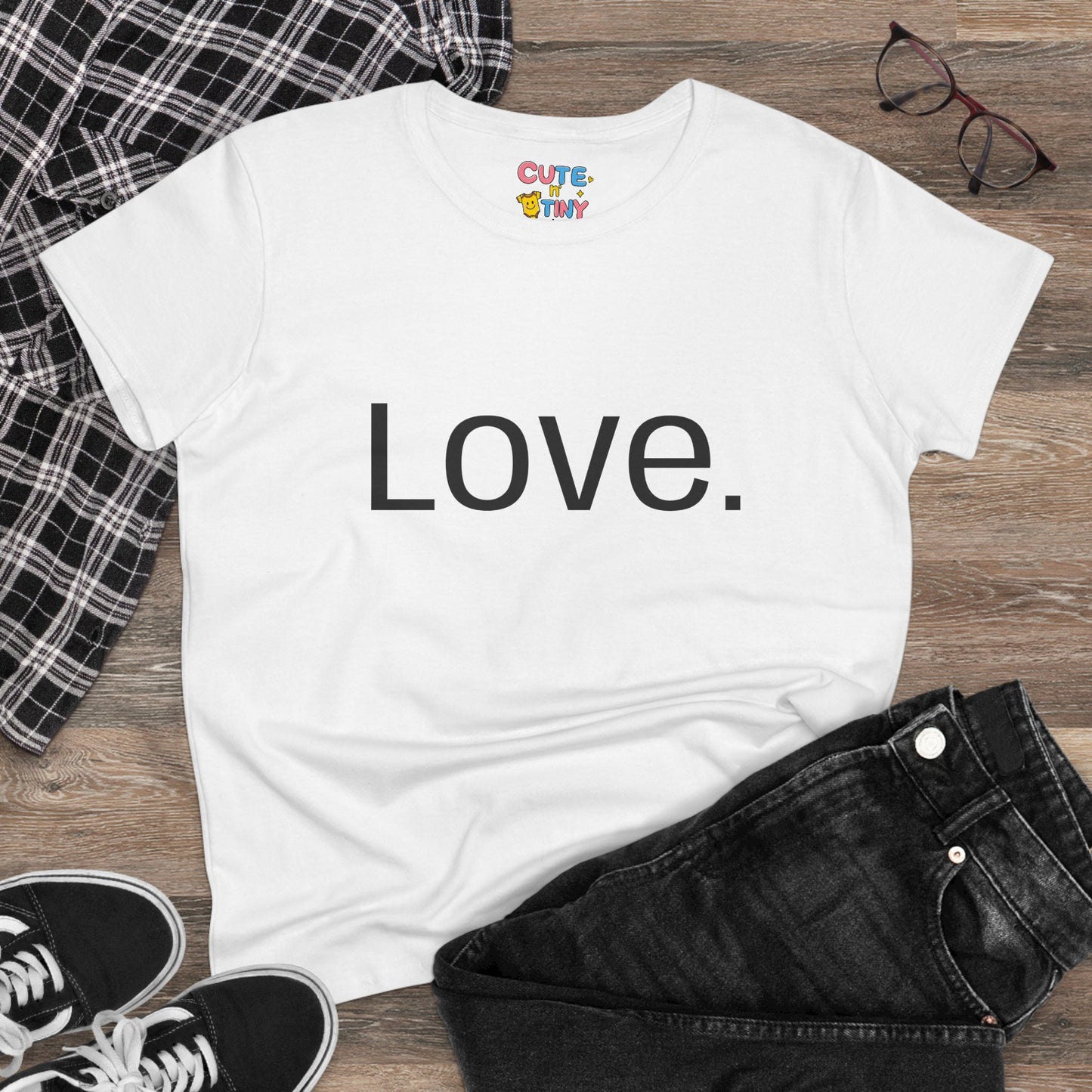 White t-shirt with 'Green is the new Cool' text on a wooden surface with casual items.
