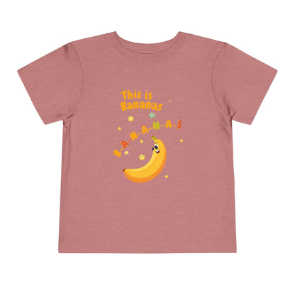 Pink t-shirt with a banana graphic and text on a white background