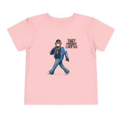 Pink t-shirt with a graphic of a person wearing a mask and text 'THEY NOT LIKE US' on a white background