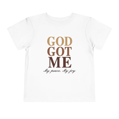 White t-shirt with 'GOD GOT ME' text in gold and black on a white background