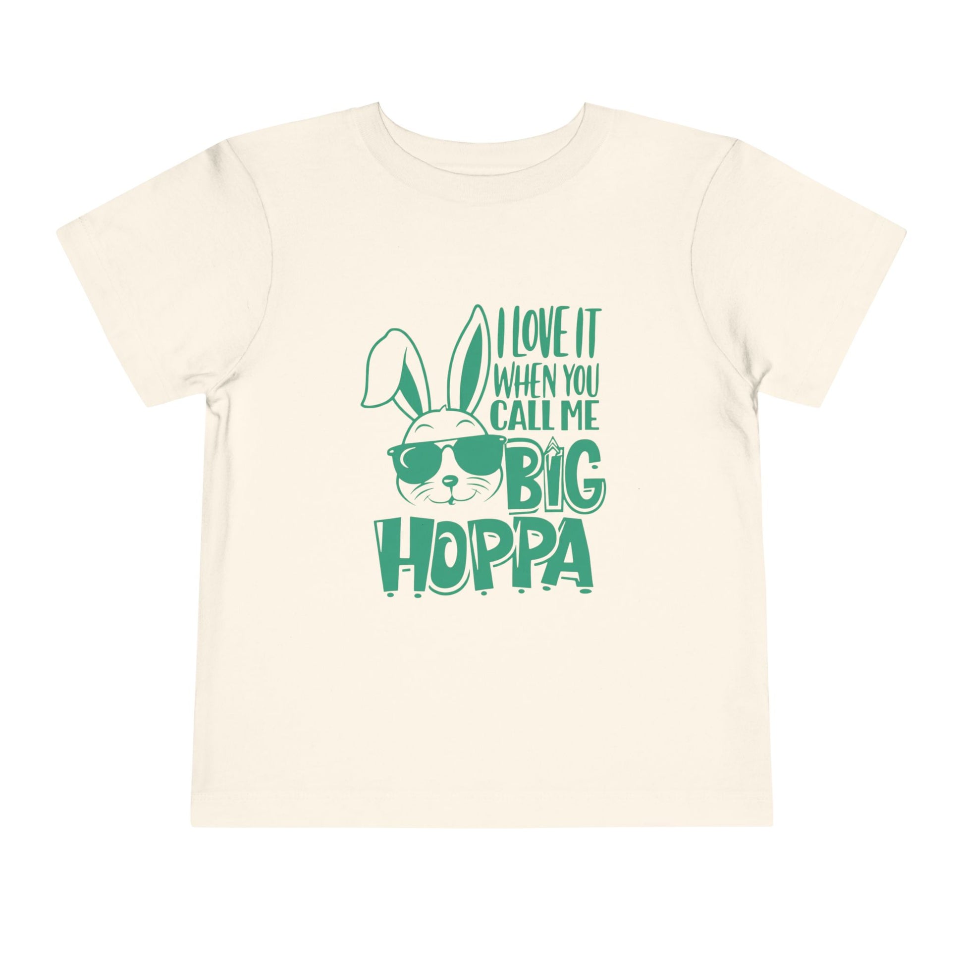 Beige t-shirt with green text and bunny graphic on a white background
