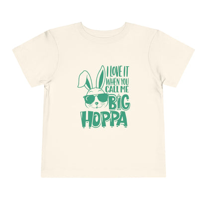 Beige t-shirt with green text and bunny graphic on a white background