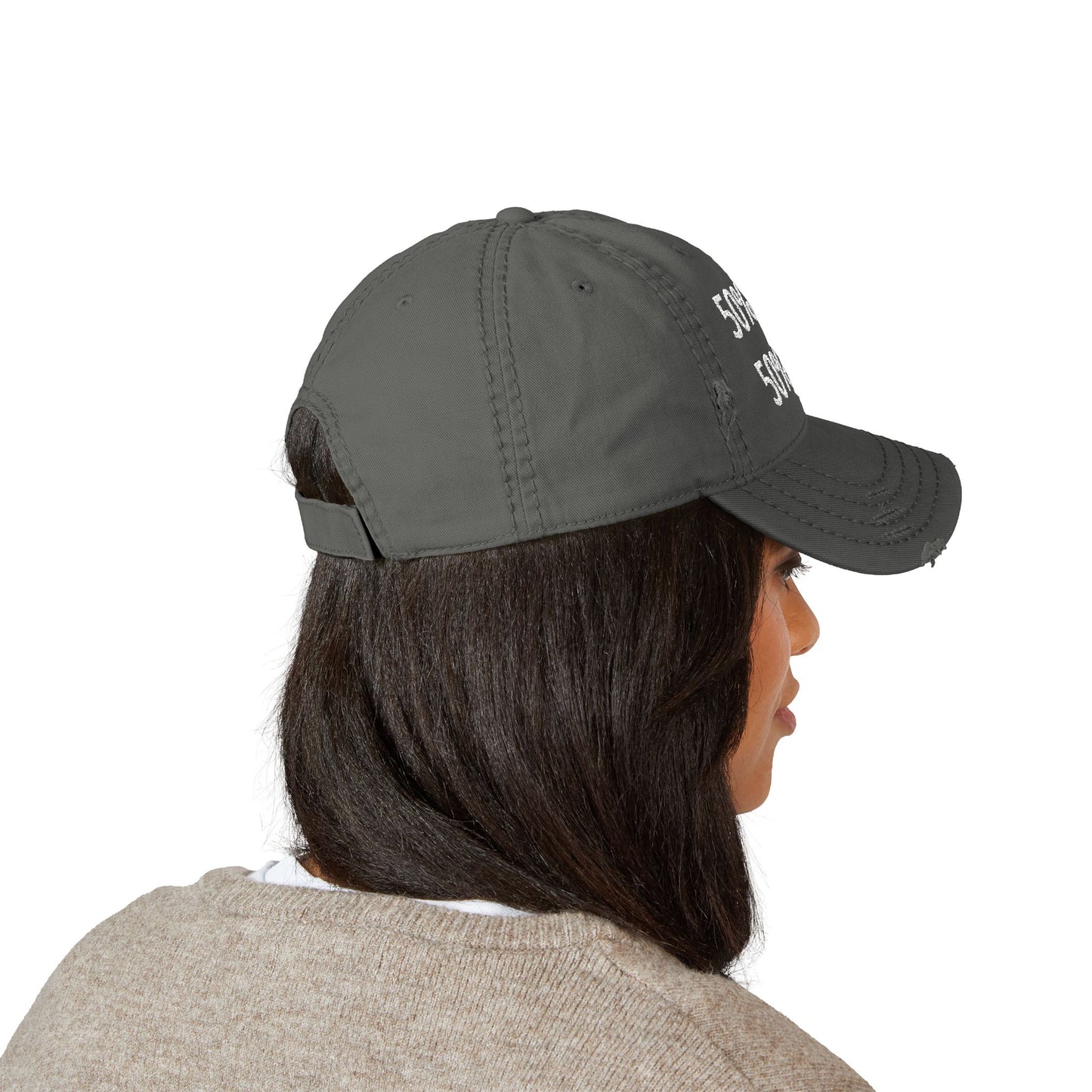 Person wearing a dark gray cap with a brand logo on a white background