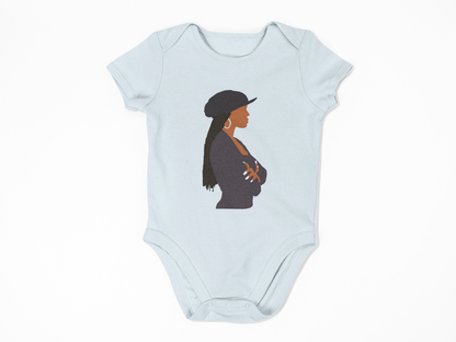 Light blue baby onesie with a graphic of a woman wearing a hat on a white background