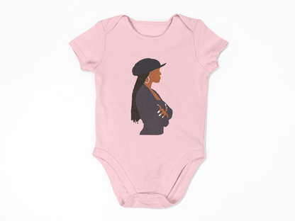Pink baby onesie with a silhouette of a woman wearing a hat on a white background