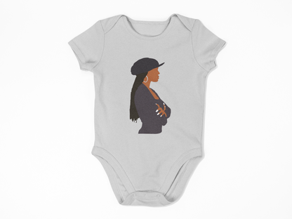 Gray baby onesie with a graphic of a woman wearing a hat on a white background